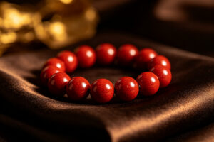 Cinnabar red beaded bracelet on dark silk, spiritual protection jewelry
