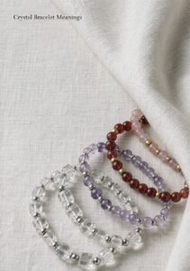 Crystal bracelets with clear quartz, amethyst, cinnabar and agate beads on a linen background